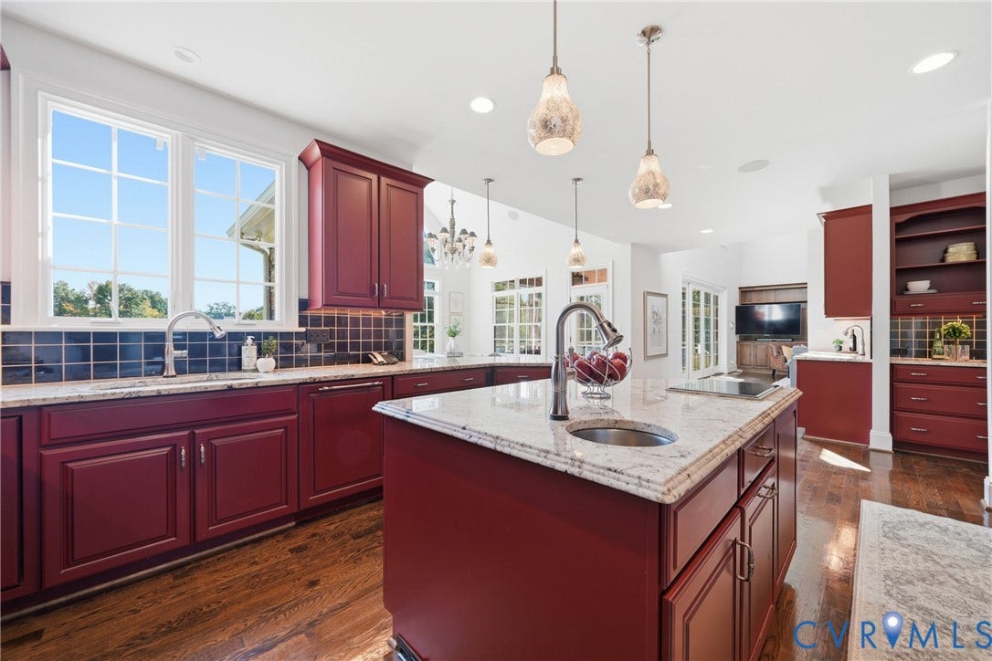 Gourmet kitchen featuring a spacious island and 3 sinks, including a dedicated preparation sink.