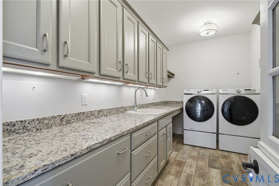 Main level laundry room with dutch door built-in cabinets, refrigerator drawers, ample counter space, and sink