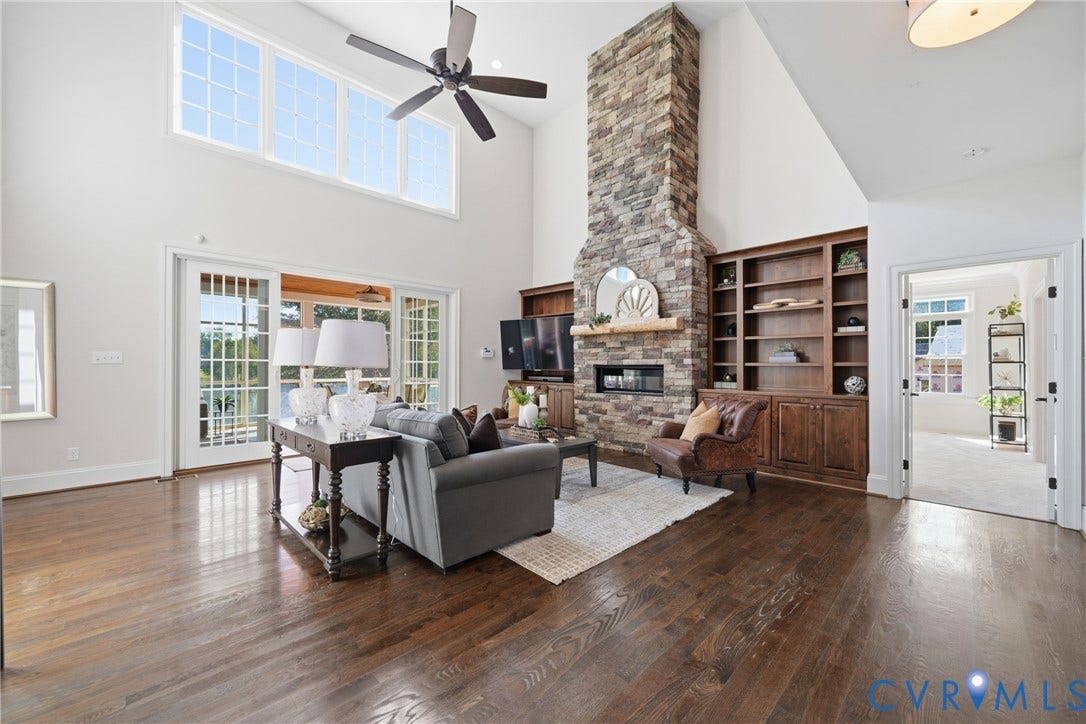 An airy living room layout with natural light, hardwood floors, and an inviting fireplace centerpiece