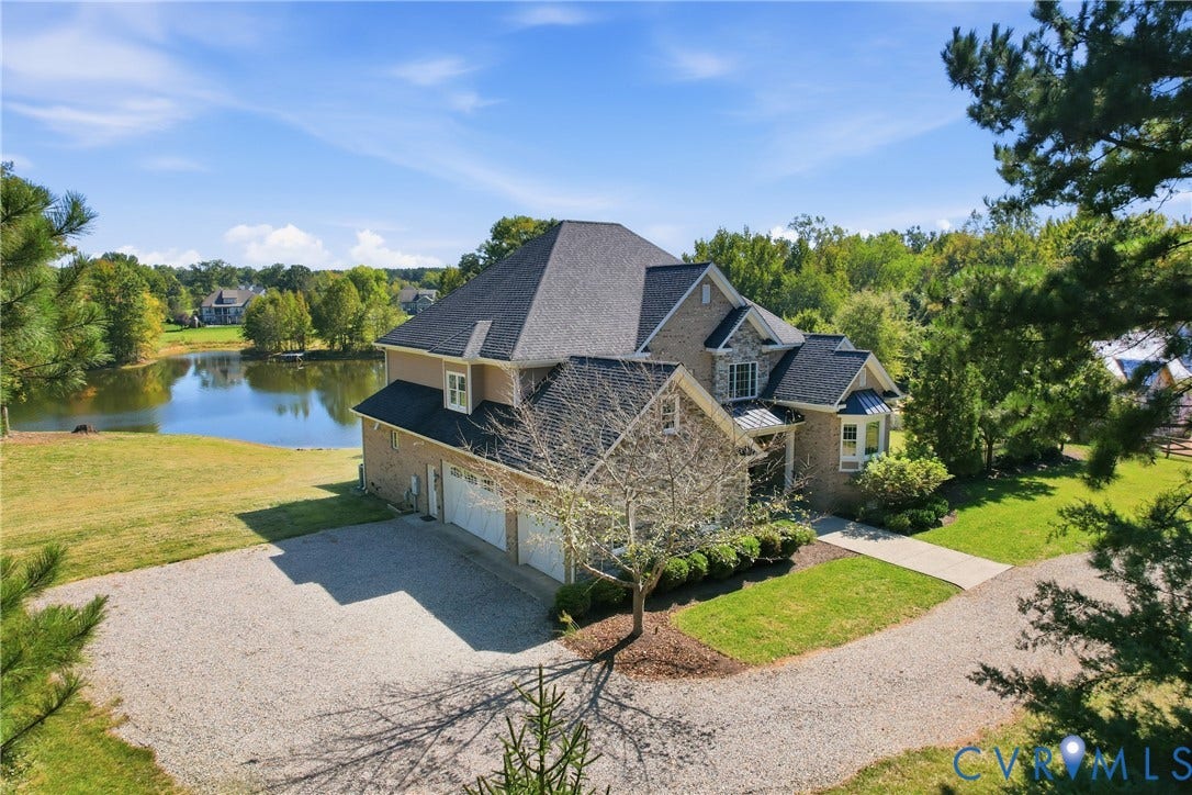 Custom-built 2-story home with private driveway, 3-car garage, and picturesque pond-side setting.
