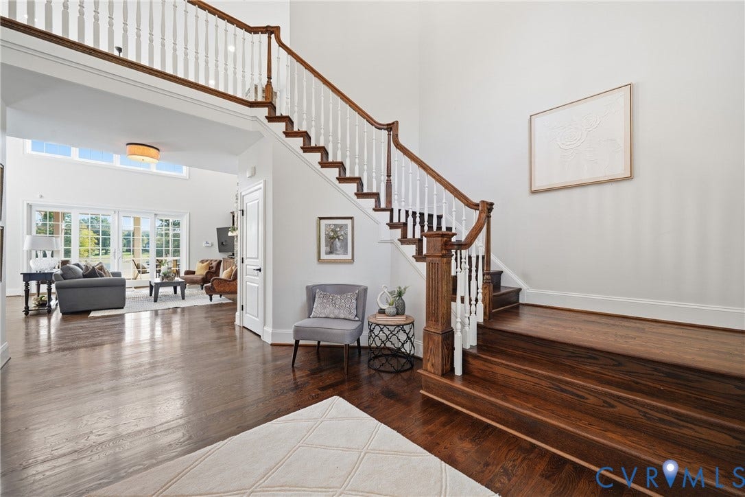 Open entryway with shining hardwood floors, coat closet; flows into the main living space
