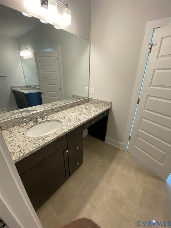 2701 St Elias Drive, #B, Richmond, VA 23294 Double vanity with integrated sinks, granite countertop, and dark wood-finish cabinetry
