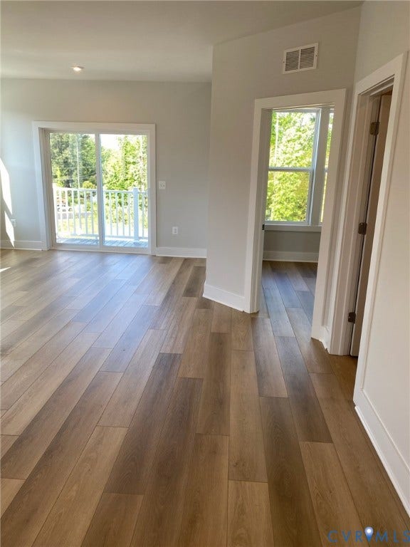 2701 St Elias Drive, #B, Richmond, VA 23294 Wood-finish flooring throughout, sliding glass door to a white-railed balcony, recessed lighting, and crisp white trim