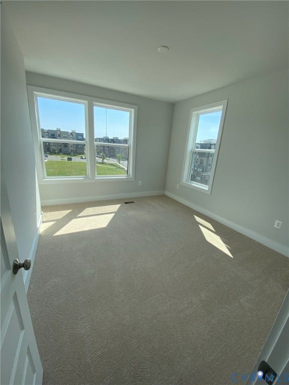 2701 St Elias Drive, #B, Richmond, VA 23294 Neutral-toned carpeting, white trim, light gray painted walls, and multiple large windows with white frames