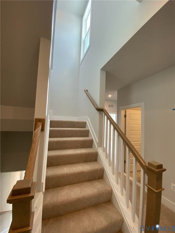 2701 St Elias Drive, #B, Richmond, VA 23294 Carpeted staircase featuring white risers, wood newel posts, and a wood handrail