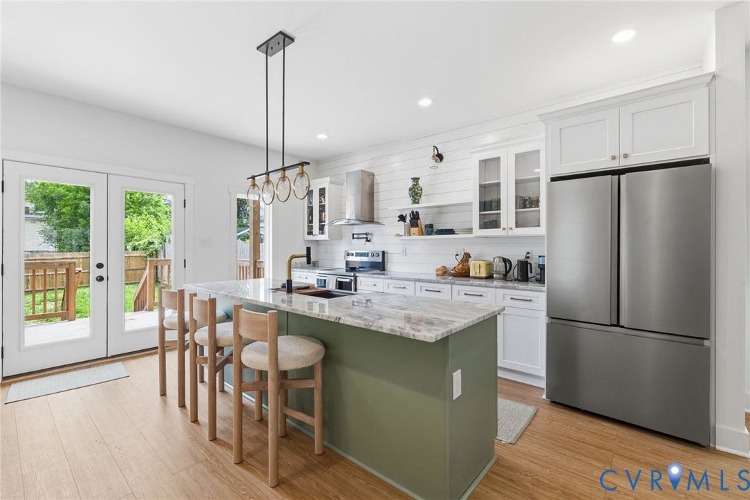2506 Porter Street, Richmond, VA 23225 Kitchen featuring wood-finish flooring, a central island with a countertop, white cabinetry with glass-front accents, and stainless steel appliances