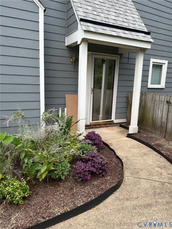 Gray horizontal siding exterior with a shingle-covered entry overhang