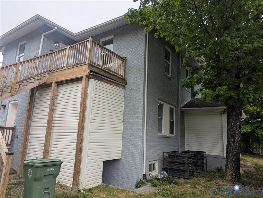 4202 Chamberlayne Avenue, Richmond, VA 23227 Grey brick exterior with white trim, featuring a wooden deck with railing, and white horizontal siding on a lower level