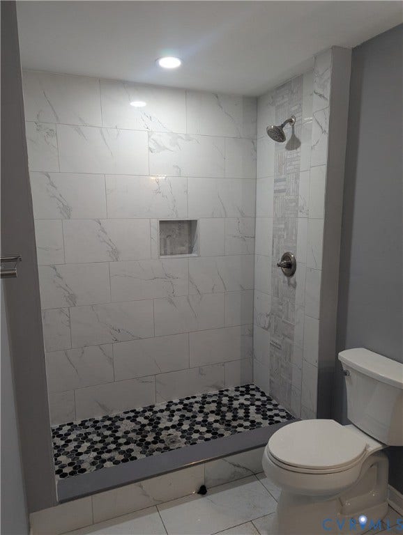 4202 Chamberlayne Avenue, Richmond, VA 23227 Spacious shower featuring large format white tile walls with veining, an accent tile strip, and a built-in shower niche