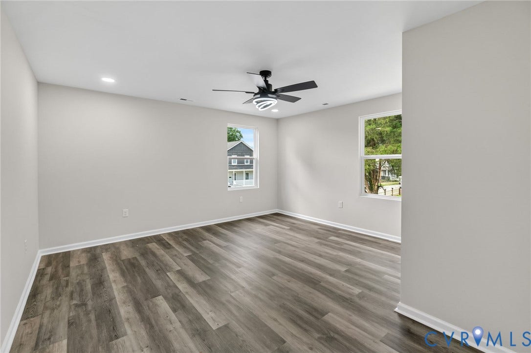 1146 Willcox Street, Petersburg, VA 23803 Spacious room featuring wood-finish flooring, light grey painted walls, white trim, and a contemporary ceiling fan