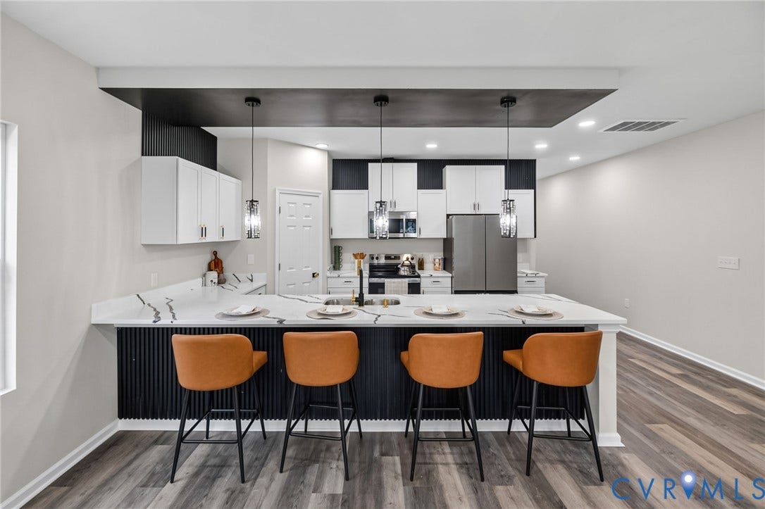 1146 Willcox Street, Petersburg, VA 23803 Spacious kitchen featuring a large island with seating, white shaker cabinetry, stainless steel appliances, and wood-finish flooring