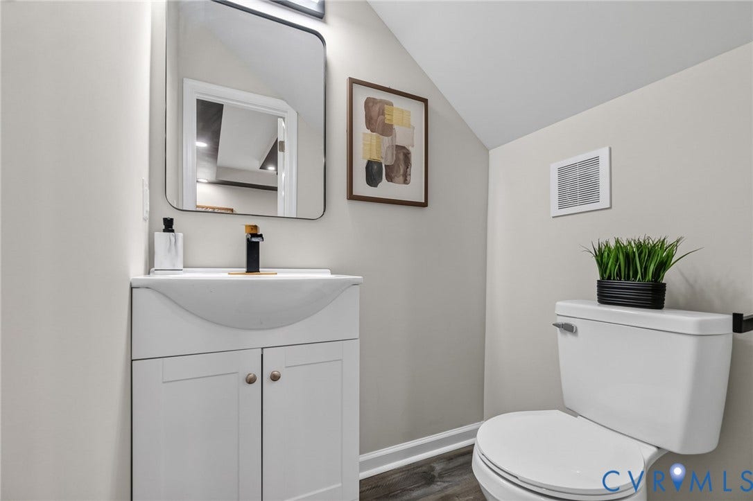 1146 Willcox Street, Petersburg, VA 23803 Contemporary bathroom featuring a white vanity with integrated sink, black and gold-tone faucet, and a rectangular mirror