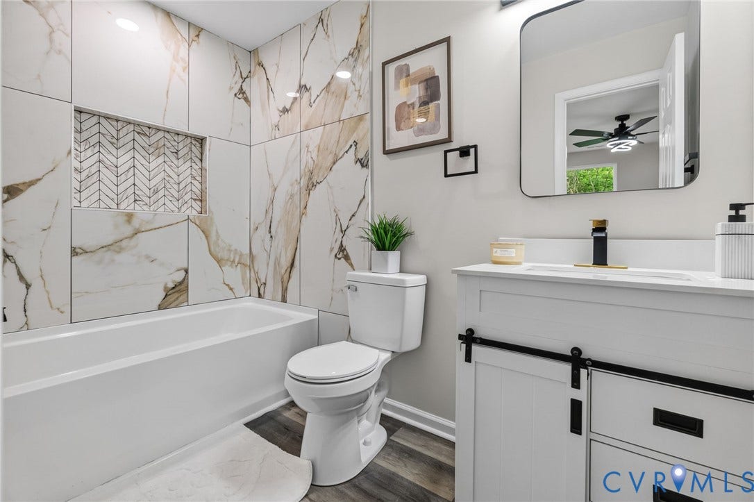 1146 Willcox Street, Petersburg, VA 23803 Bathroom featuring a white bathtub, decorative tile surround, and a built-in shower niche with herringbone mosaic tiling