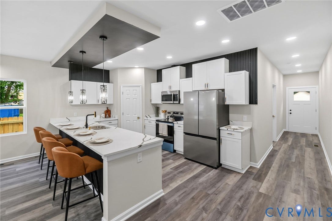 1146 Willcox Street, Petersburg, VA 23803 Modern kitchen featuring an island with a waterfall countertop, pendant lighting, white cabinetry, and stainless steel appliances