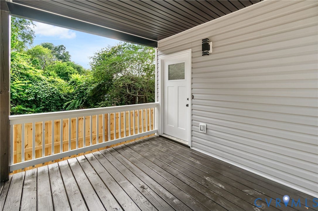 1146 Willcox Street, Petersburg, VA 23803 Covered outdoor deck featuring wood-finish flooring, white spindle railing, and a privacy fence