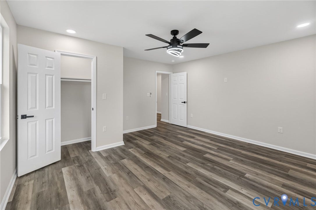 1146 Willcox Street, Petersburg, VA 23803 Spacious room featuring wide plank wood-finish flooring, a modern black ceiling fan with integrated lighting, recessed lighting, a white six-panel door, and an open closet with hanging rod