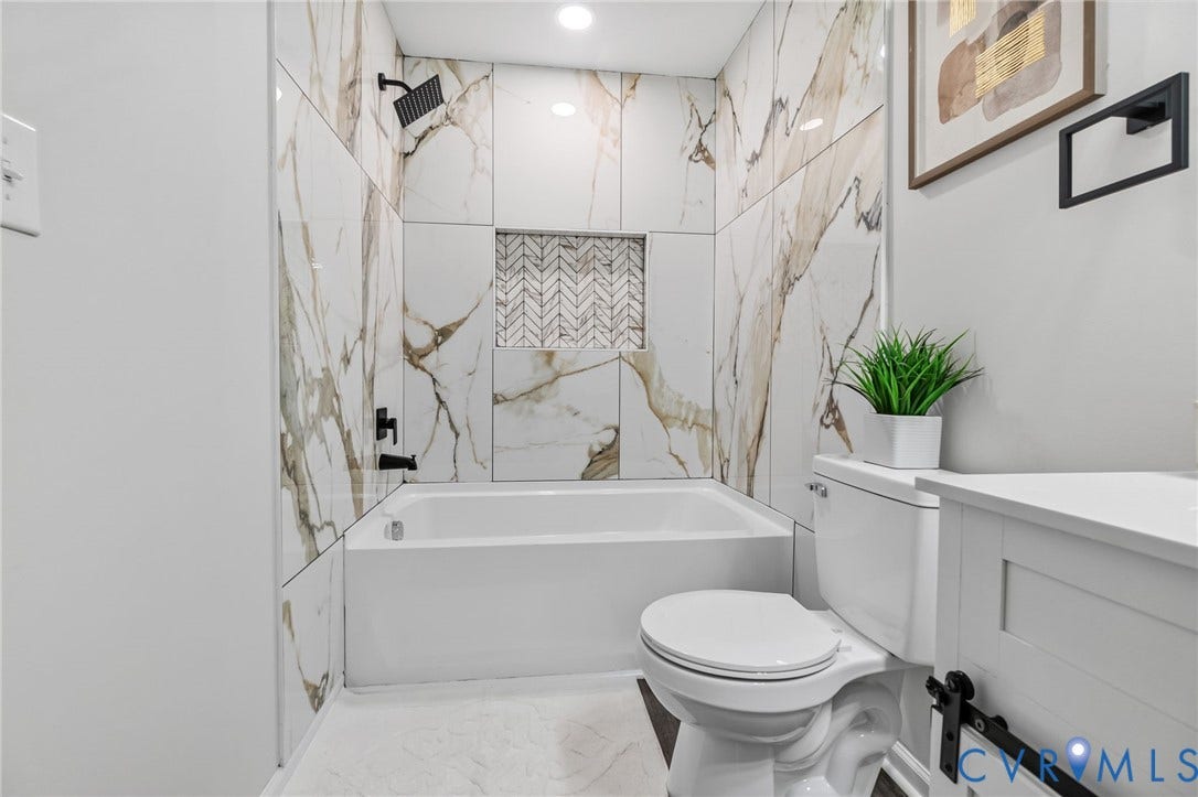 1146 Willcox Street, Petersburg, VA 23803 Full bathroom featuring a white tub, matte black fixtures, and a tiled shower surround with a decorative niche