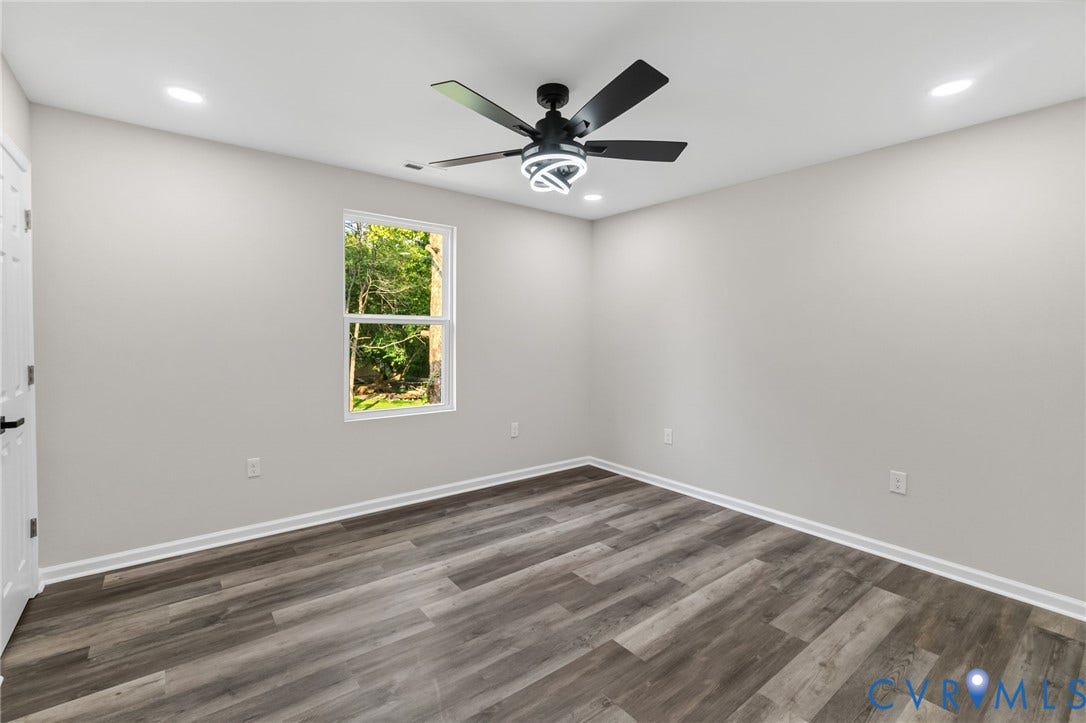 1146 Willcox Street, Petersburg, VA 23803 Spacious room featuring wood-finish flooring and a contemporary black ceiling fan with integrated lighting