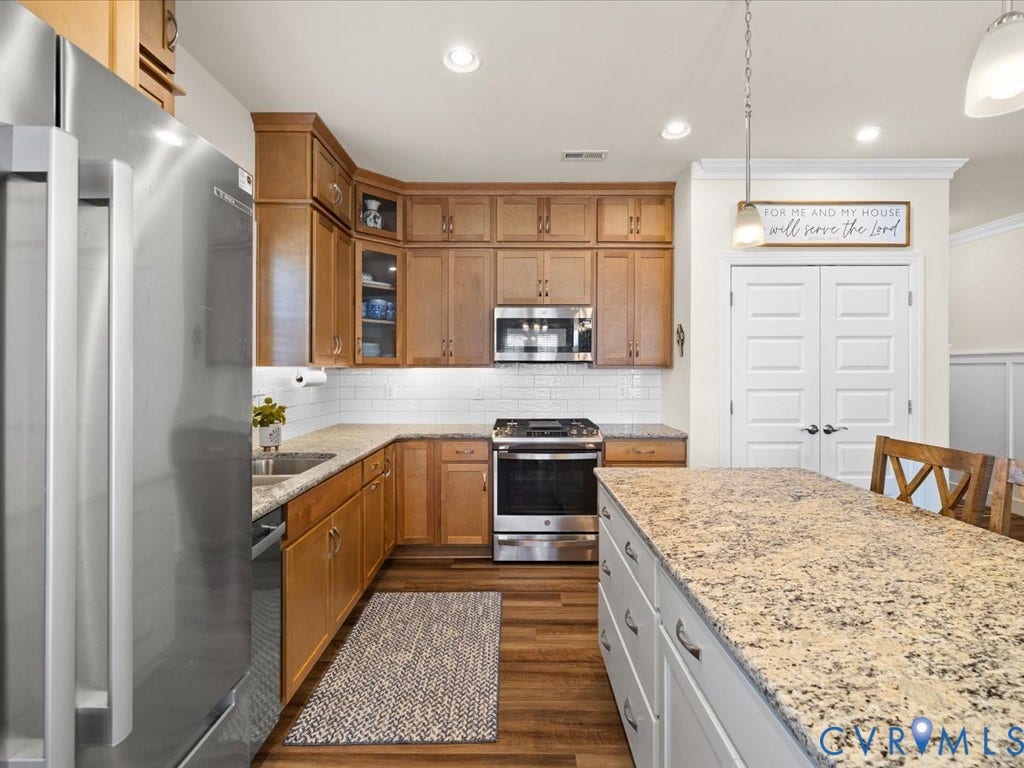 1801 Outrigger Drive, Meadowville Landing, Chesterfield, VA 23836 Wood-finish flooring with recessed lighting, stainless steel appliances, wood cabinetry, and a subway tile backsplash