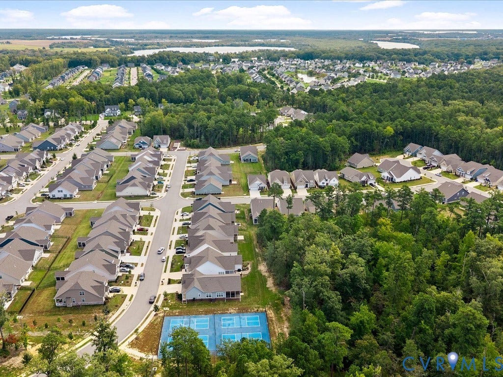 1801 Outrigger Drive, Meadowville Landing, Chesterfield, VA 23836 Aerial community overview featuring a residential neighborhood, paved streets, and a forested perimeter