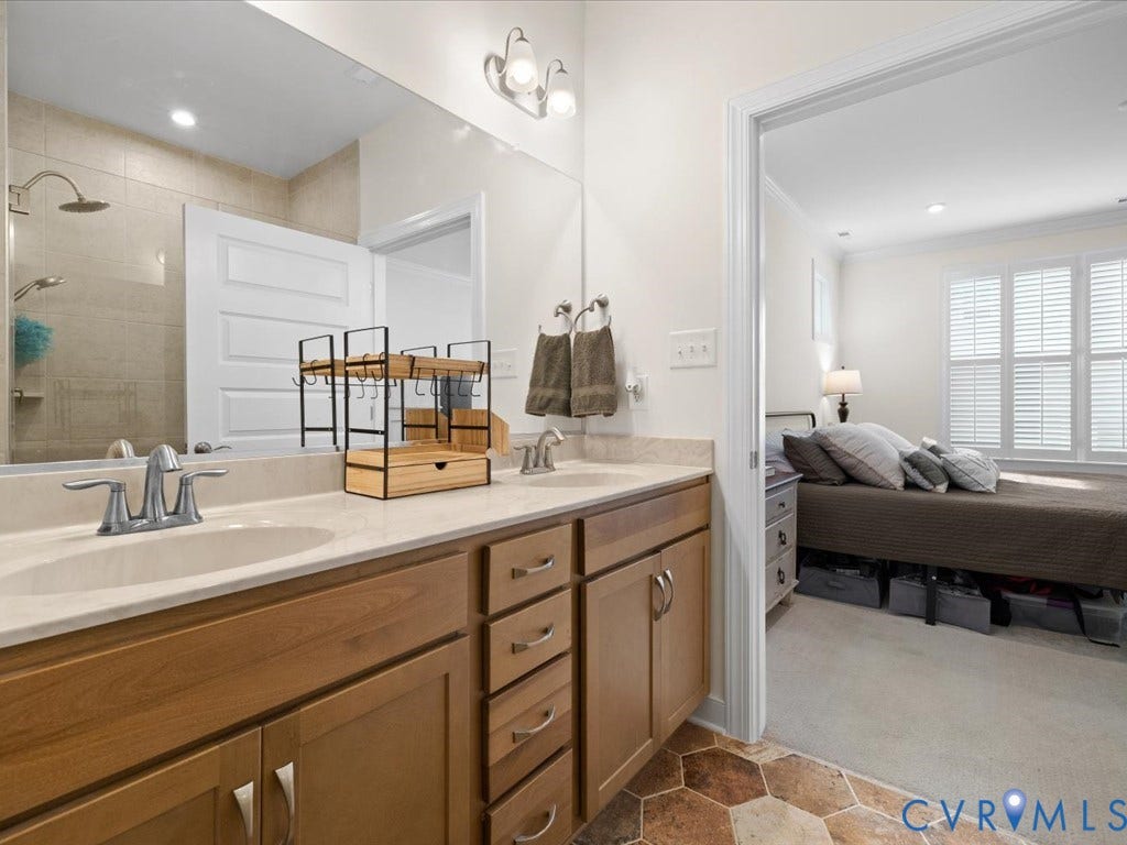 1801 Outrigger Drive, Meadowville Landing, Chesterfield, VA 23836 Bathroom featuring a double vanity with light wood cabinetry, light-toned countertop, and dual sinks