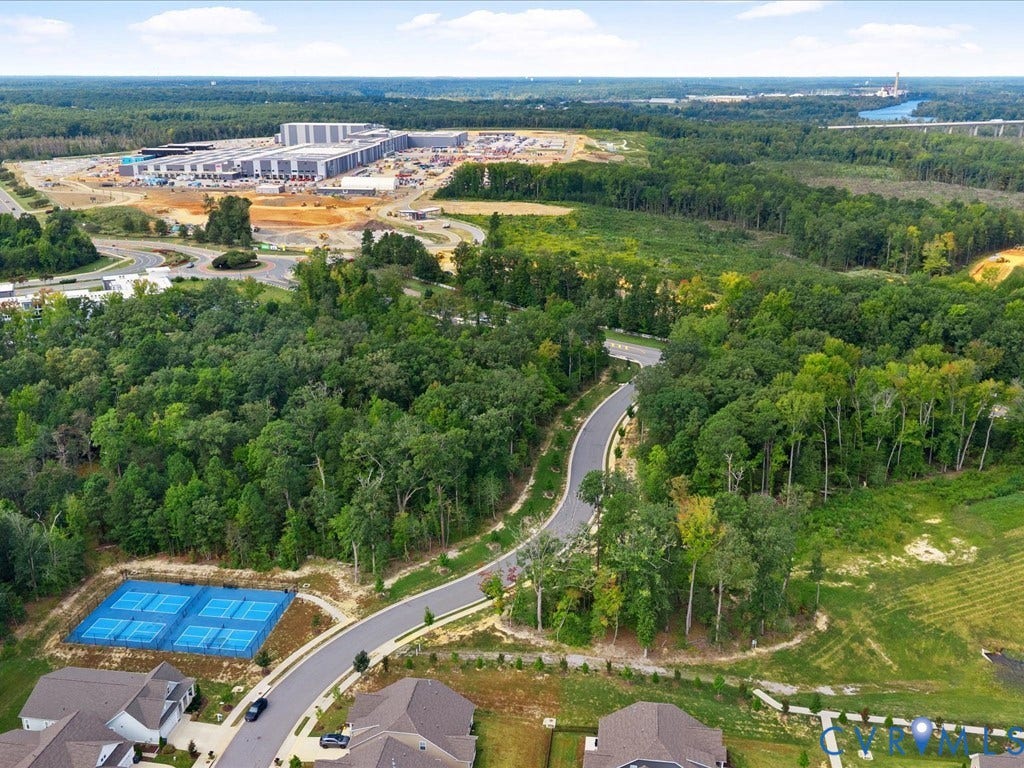 1801 Outrigger Drive, Meadowville Landing, Chesterfield, VA 23836 Manicured pickleball courts, paved residential street, mature tree canopy, and nearby industrial development