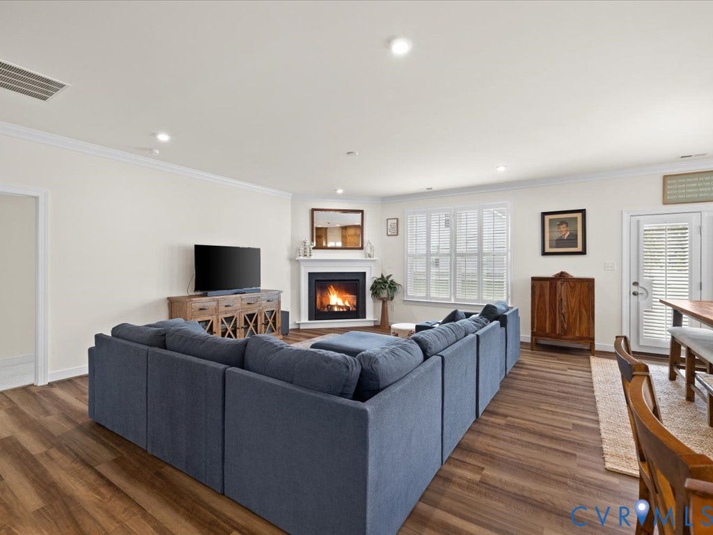 1801 Outrigger Drive, Meadowville Landing, Chesterfield, VA 23836 Spacious living area featuring wood-finish flooring, a corner fireplace with a white mantel, recessed lighting, and white plantation shutters