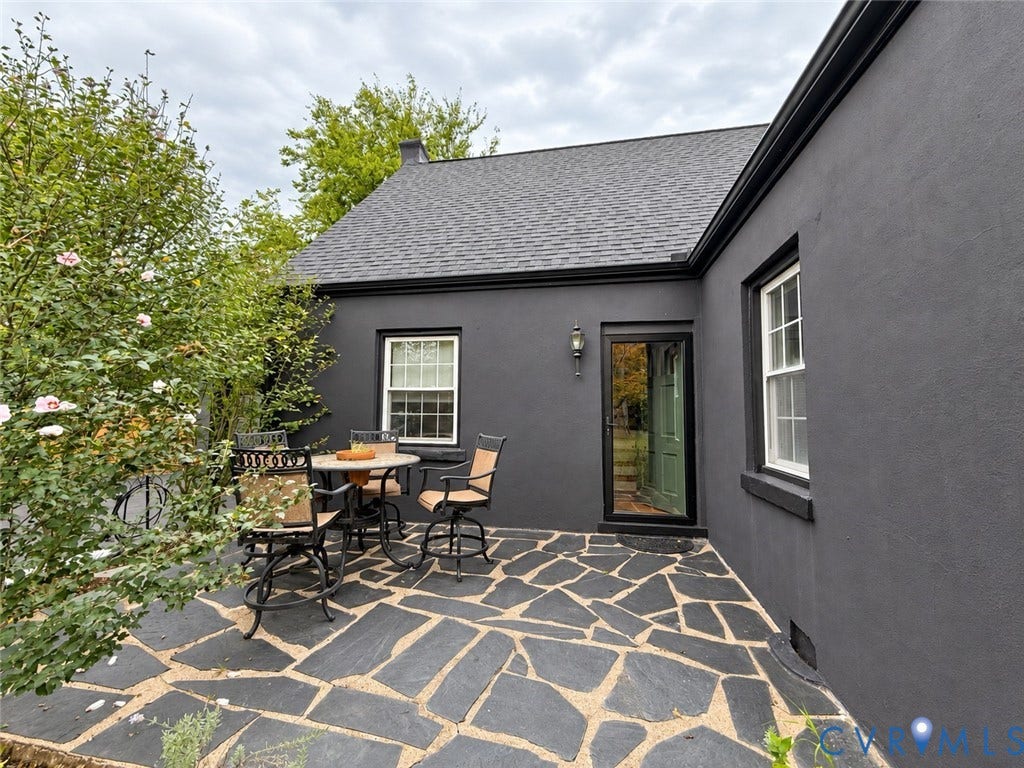 518 Central Terrace, Hopewell, VA 23860 Stucco exterior featuring a flagstone patio, black gutters, and a prominent exterior light fixture