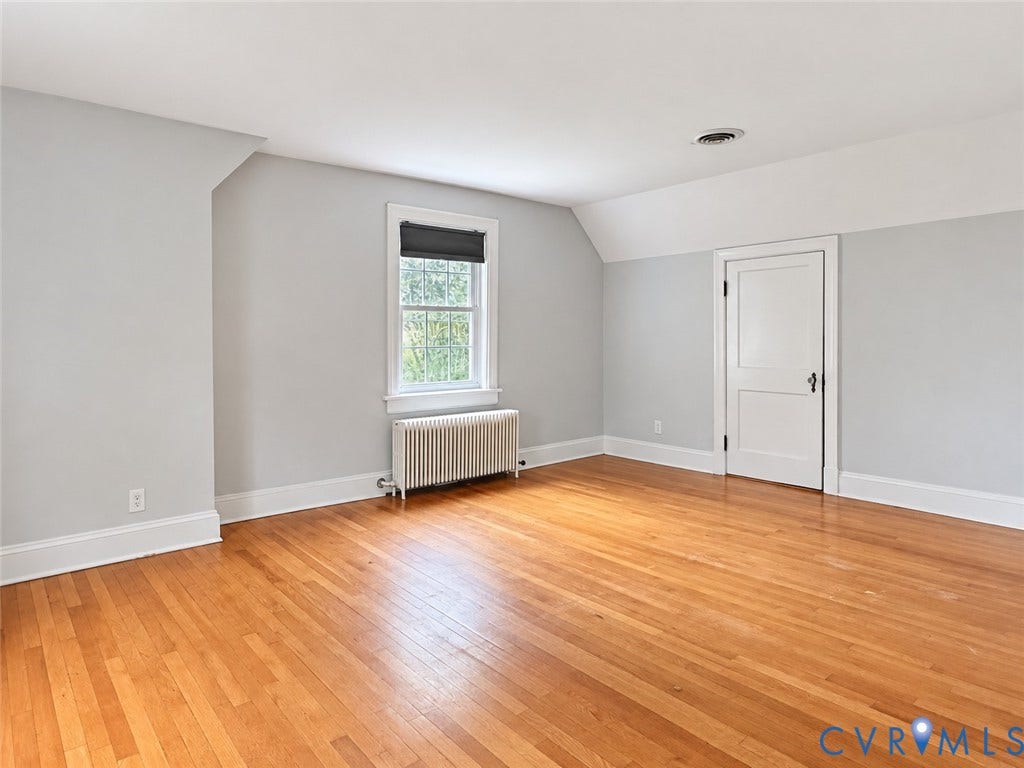 518 Central Terrace, Hopewell, VA 23860 Hardwood flooring, white baseboards, window with roller shade, wall-mounted radiator, and a white paneled door