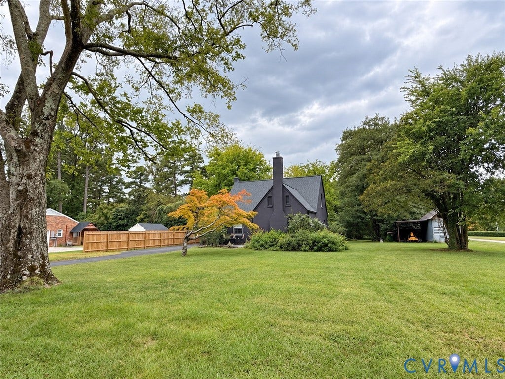518 Central Terrace, Hopewell, VA 23860 Expansive lot featuring a substantial lawn, mature trees, a privacy fence, and a detached outbuilding