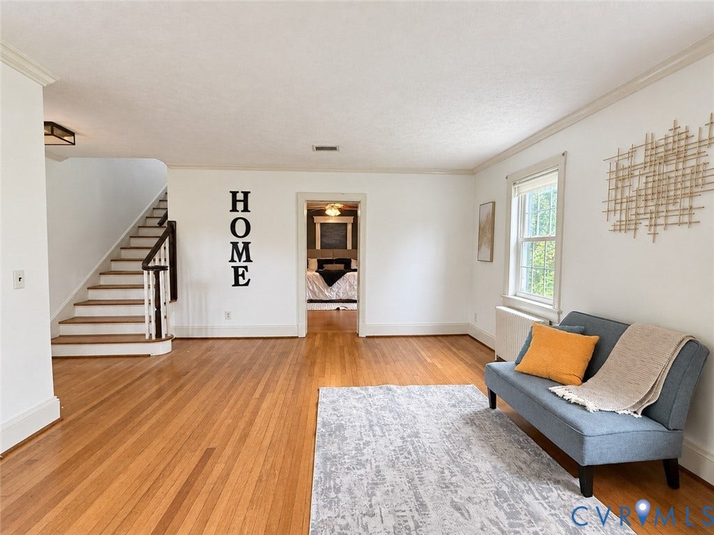 518 Central Terrace, Hopewell, VA 23860 Hardwood flooring throughout, white painted walls, natural light from a window, and a staircase with dark wood handrails