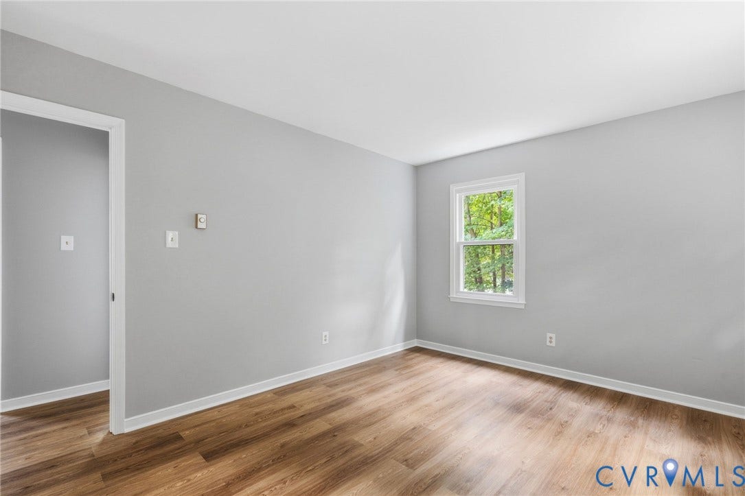 5571 Heatherhill Drive, Whale Rock, North Chesterfield, VA 23234 Wood-finish flooring, light grey wall paint, and a white-framed window