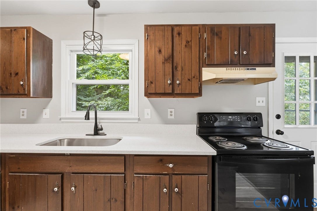 5571 Heatherhill Drive, Whale Rock, North Chesterfield, VA 23234 Kitchen featuring wood-finish cabinetry, light-toned countertops, a stainless steel sink, and a black electric range with an oven