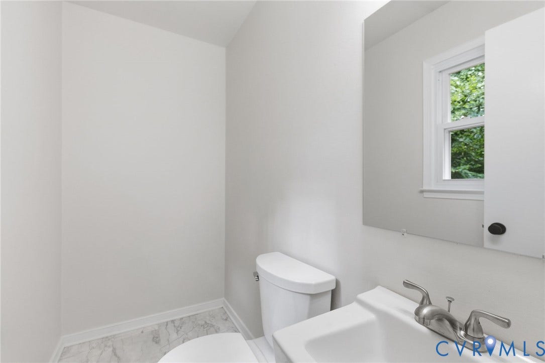 5571 Heatherhill Drive, Whale Rock, North Chesterfield, VA 23234 White ceramic toilet with a wall-mounted sink, brushed nickel faucet, and a wall mirror