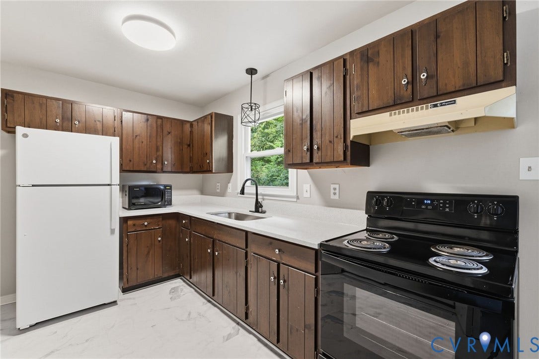 5571 Heatherhill Drive, Whale Rock, North Chesterfield, VA 23234 White countertops, dark wood cabinetry, stainless steel sink, black range, and window