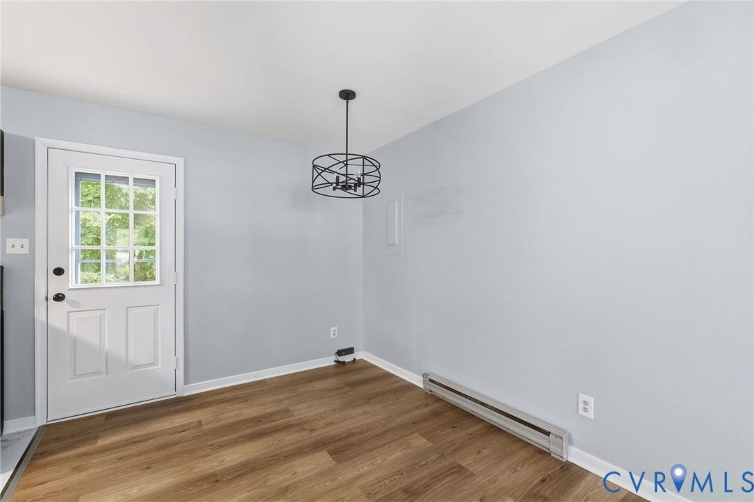 5571 Heatherhill Drive, Whale Rock, North Chesterfield, VA 23234 Wood-finish flooring, white paneled door with divided light window, and a contemporary black chandelier
