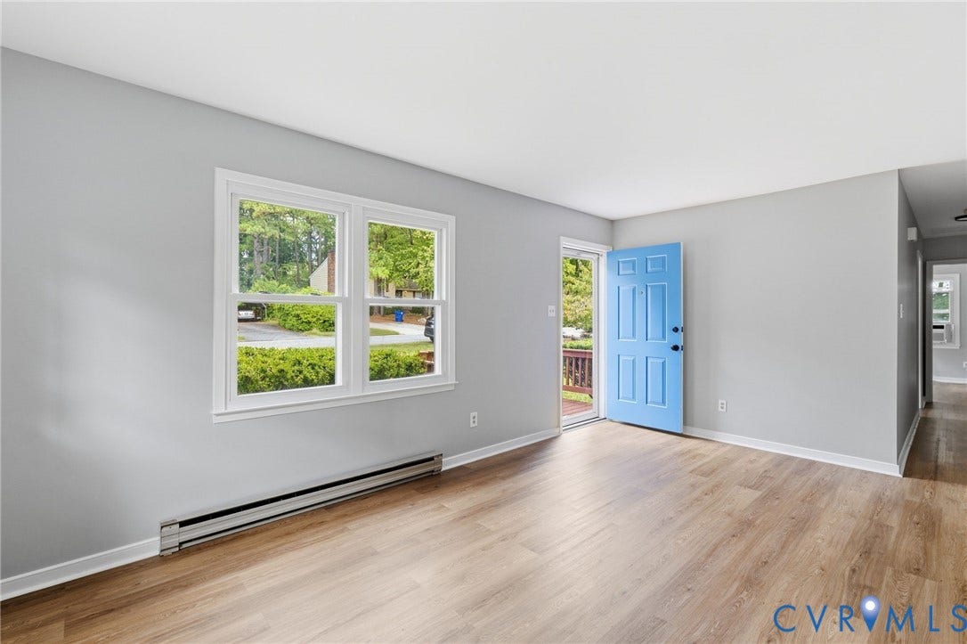 5571 Heatherhill Drive, Whale Rock, North Chesterfield, VA 23234 Light wood-finish flooring, white window trim, light gray wall paint, and a bright blue entry door