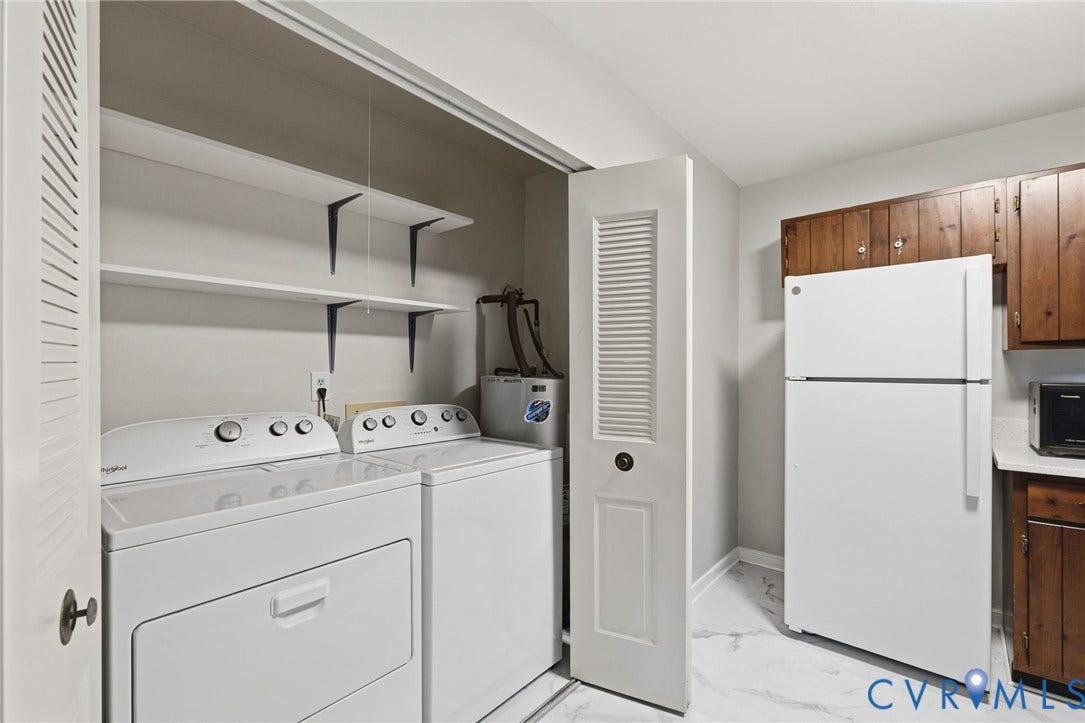 5571 Heatherhill Drive, Whale Rock, North Chesterfield, VA 23234 Laundry closet with louvered bi-fold doors, stacked shelving, and adjacent wood cabinetry