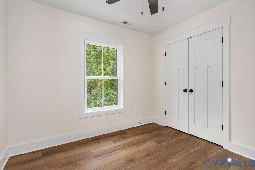 7605 Oster Drive, Chamberlayne Farms Area, Henrico, VA 23227 Wood-finish flooring, white trim, white paneled double doors with matte black hardware, and a window with white casing