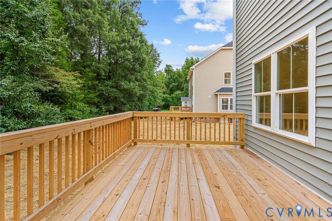 7605 Oster Drive, Chamberlayne Farms Area, Henrico, VA 23227 Expansive wood deck with natural wood railing, featuring light-colored siding and large windows