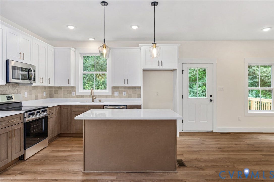 7605 Oster Drive, Chamberlayne Farms Area, Henrico, VA 23227 Kitchen featuring wood-finish flooring, a central island with white countertop, white upper cabinetry, brown lower cabinetry, and stainless steel appliances