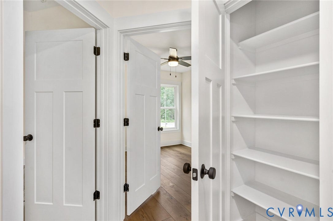 7605 Oster Drive, Chamberlayne Farms Area, Henrico, VA 23227 White interior doors with dark hardware, recessed built-in shelving, wood-finish flooring, and a ceiling fan