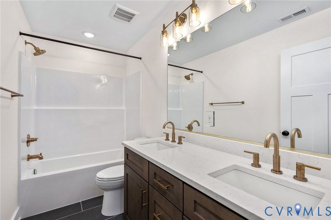 7605 Oster Drive, Chamberlayne Farms Area, Henrico, VA 23227 Double vanity with integrated sinks, white countertop, dark wood-finish cabinetry, and gold-tone fixtures