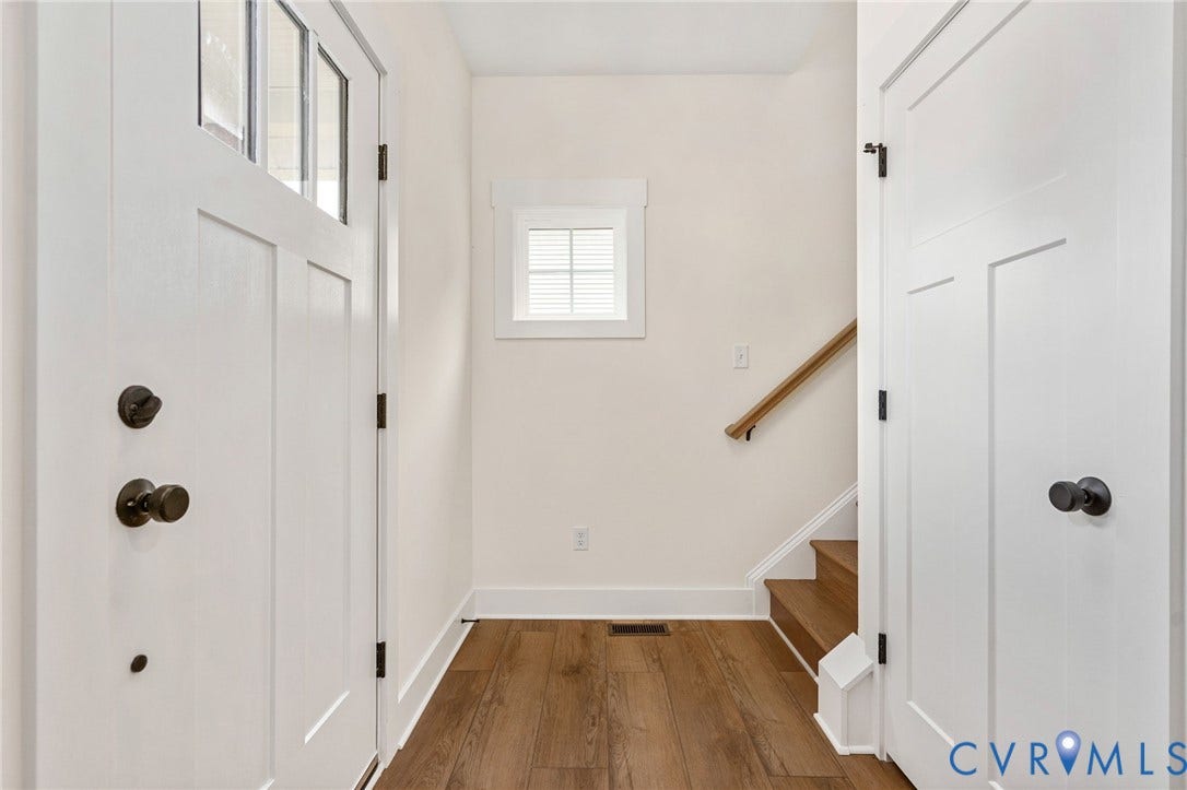 7605 Oster Drive, Chamberlayne Farms Area, Henrico, VA 23227 Entryway featuring a white paneled door with glass inserts, wood-finish flooring, a small window with blinds, and a staircase with a wood handrail