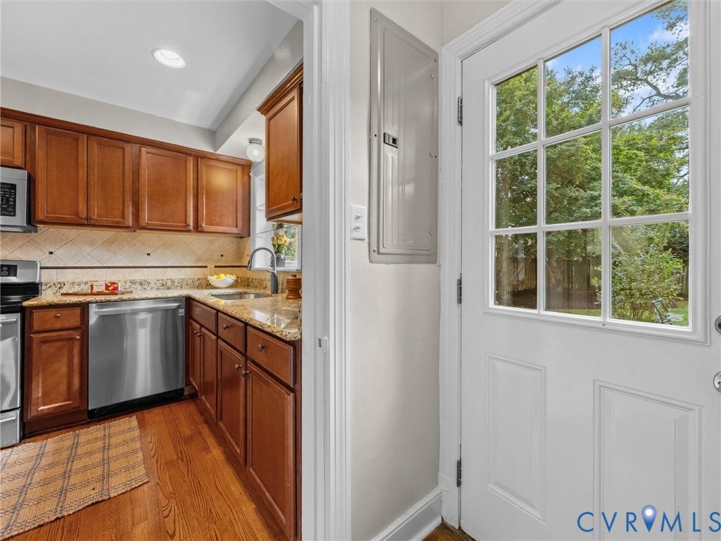 1113 E Durwood Crescent, Tuckahoe Area, Henrico, VA 23229 Kitchen featuring wood-finish flooring, wood cabinetry, stainless steel appliances, and light-toned countertops with a tiled backsplash