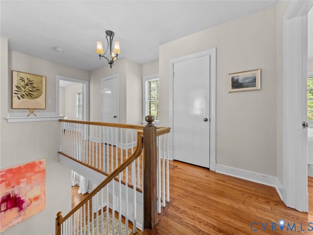 1113 E Durwood Crescent, Tuckahoe Area, Henrico, VA 23229 Hardwood flooring, painted white walls, white trim, wood handrail with white balusters, and a three-light chandelier