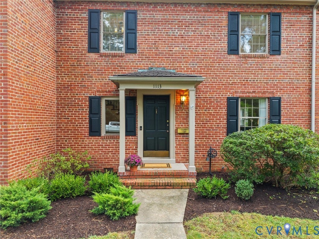 1113 E Durwood Crescent, Tuckahoe Area, Henrico, VA 23229 Red brick exterior with dark shutters, covered entry, front door with transom window, and mature landscaping