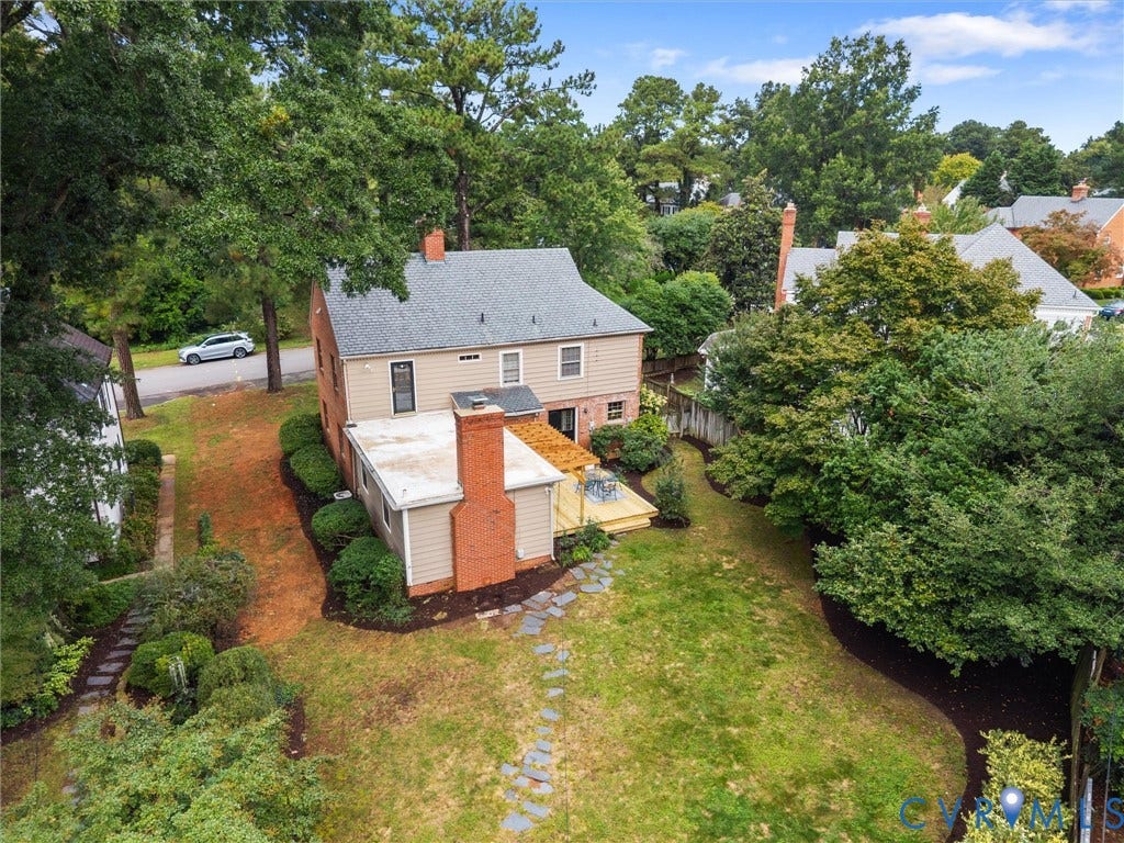 1113 E Durwood Crescent, Tuckahoe Area, Henrico, VA 23229 Expansive backyard featuring a manicured lawn, mature trees, a wooden deck, and a stone paver pathway