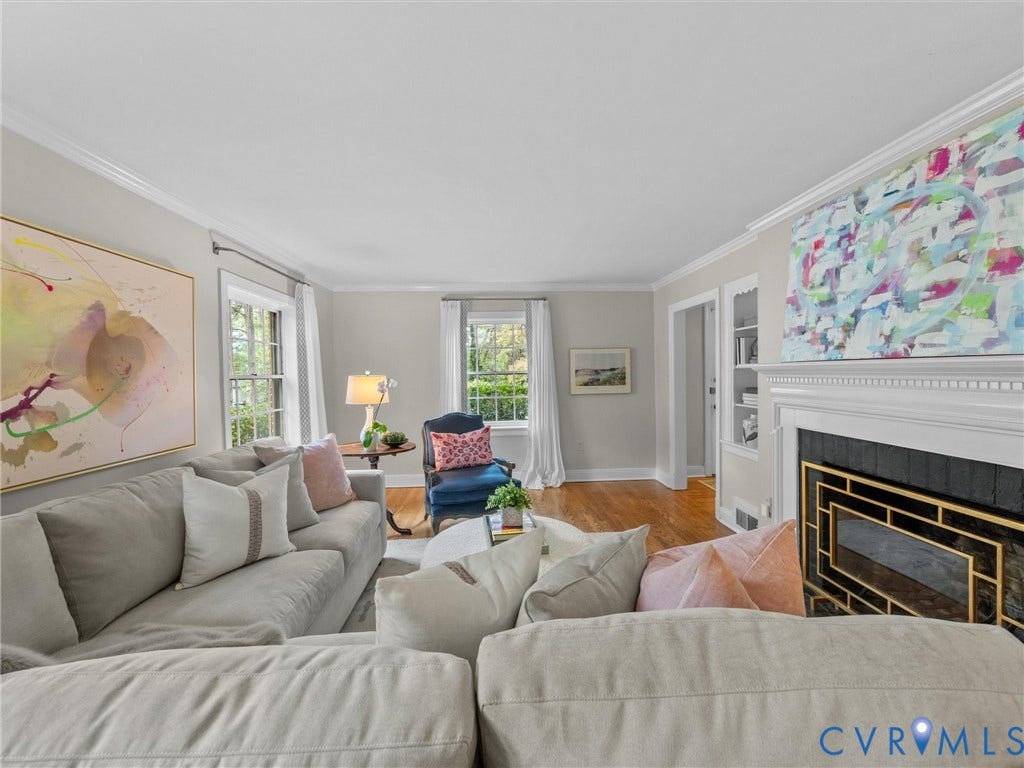 1113 E Durwood Crescent, Tuckahoe Area, Henrico, VA 23229 Living area featuring a white crown molding, wood-finish flooring, a decorative fireplace with a black surround and gold-toned detailing, built-in shelving, and multiple windows