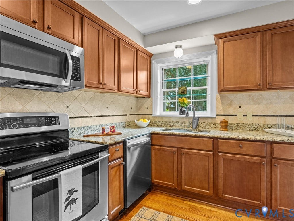 1113 E Durwood Crescent, Tuckahoe Area, Henrico, VA 23229 Wood-finish flooring, stainless steel appliances, upper and lower wood-finish cabinetry, light-toned stone countertops, and a tile backsplash